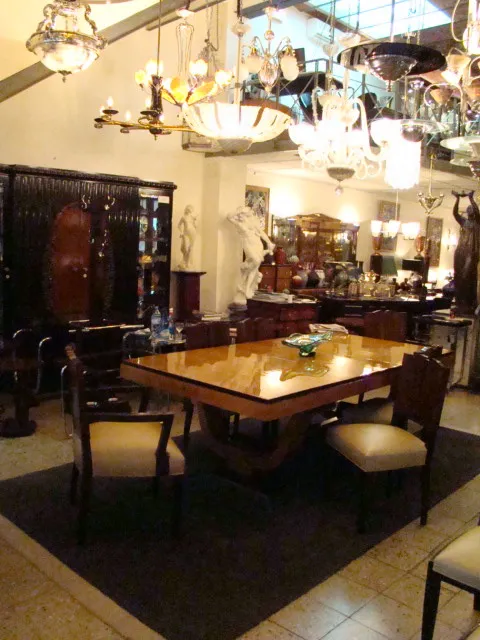 Quattro sedie antiche in un ambiente decorativo con luci eleganti e mobili.