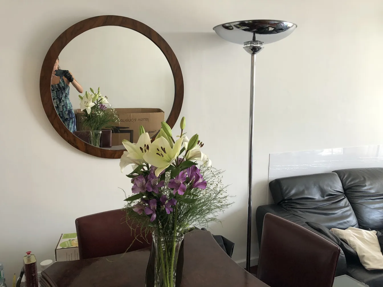 angolo con fiori e specchio, 8 sedie antiche sullo sfondo