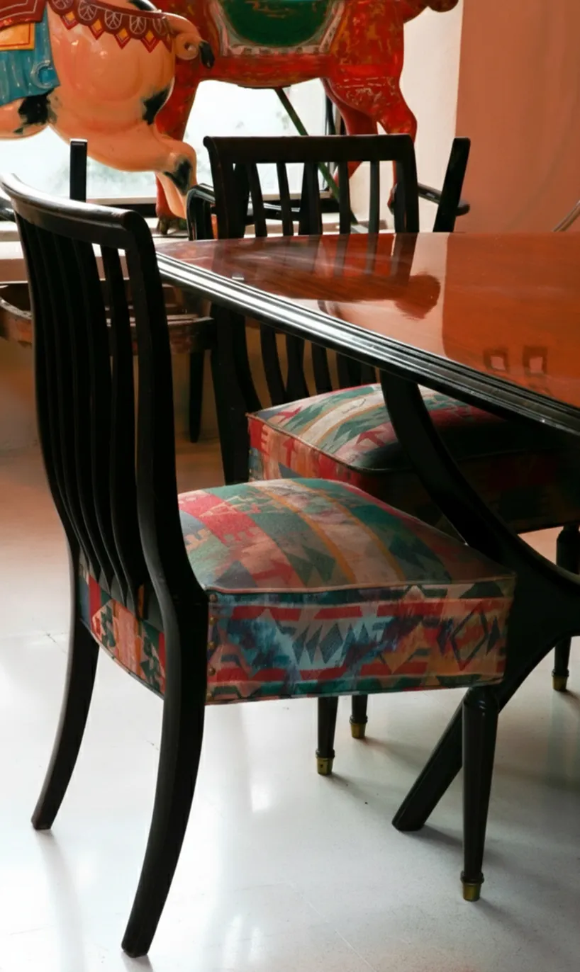 Eight antique chairs of various colors to restore, in a cozy setting.