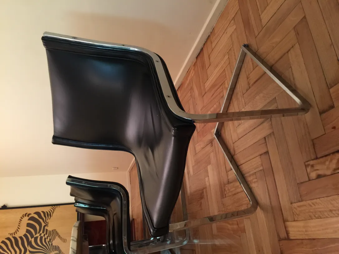 Vista lateral de 10 cadeiras antigas em um ambiente aconchegante.