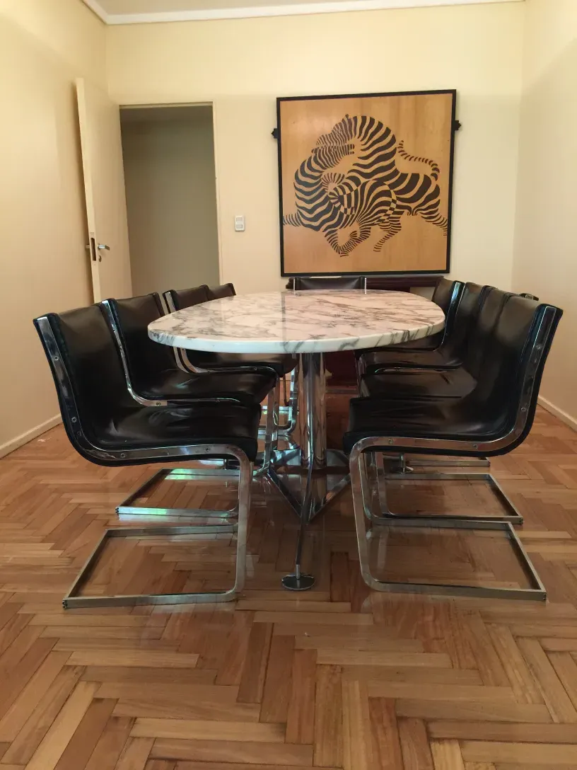 10 vintage chairs arranged around a round table, cozy setting