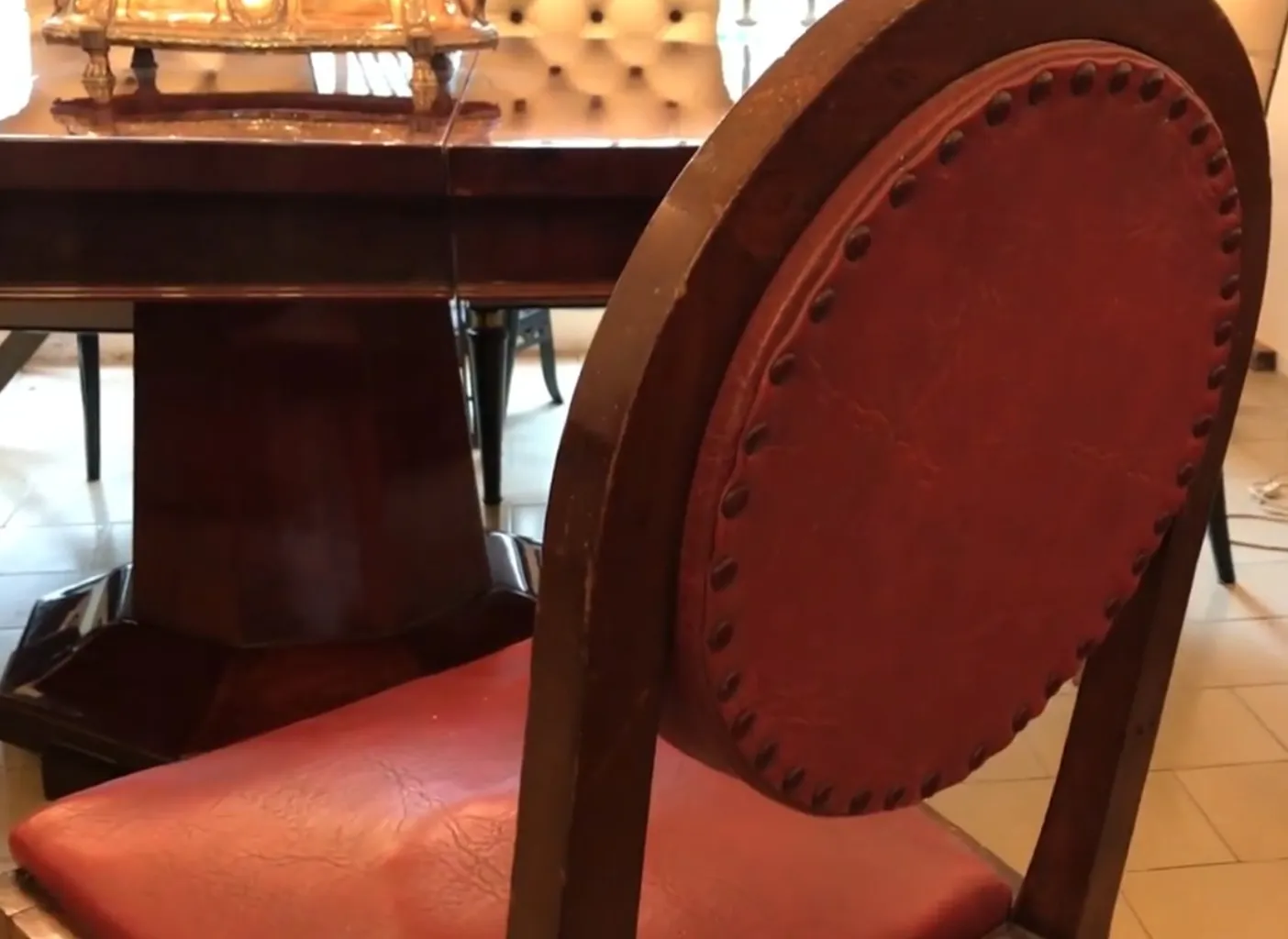 12 antique chairs with red upholstery in a refined setting.