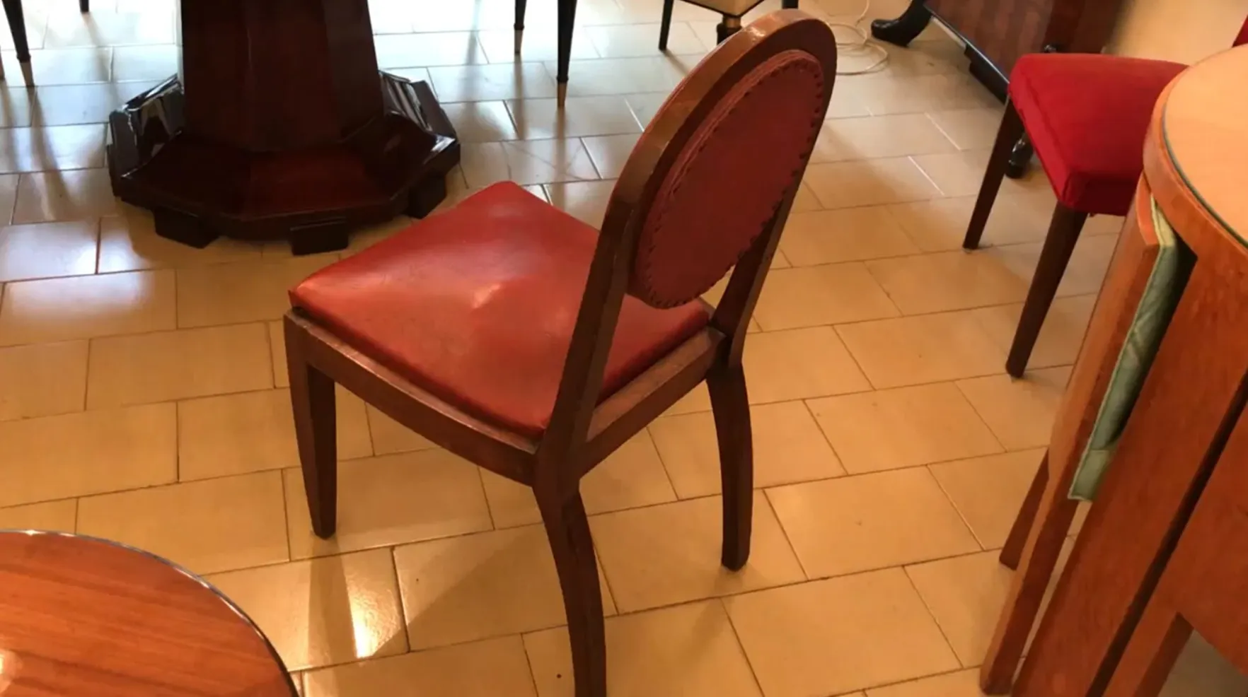 12 chairs with red upholstery in an antique setting