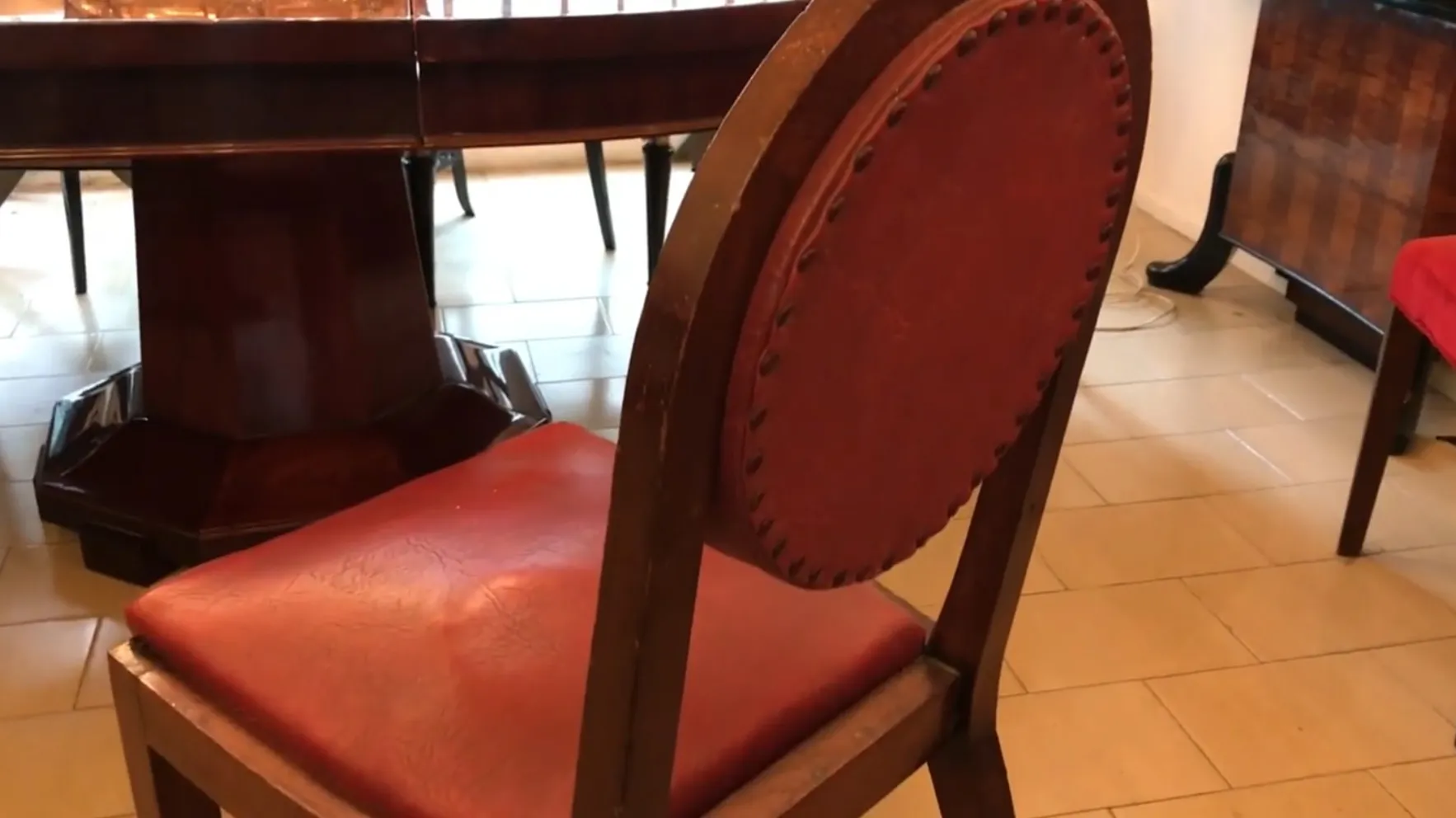 Vista de várias cadeiras antigas com estofado vermelho em um ambiente elegante