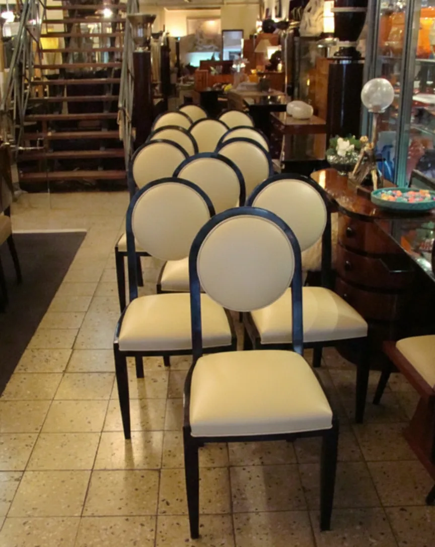 12 cadeiras antigas com encosto redondo no estilo Art Deco, prontas para restaurar, em um ambiente de antiguidade.