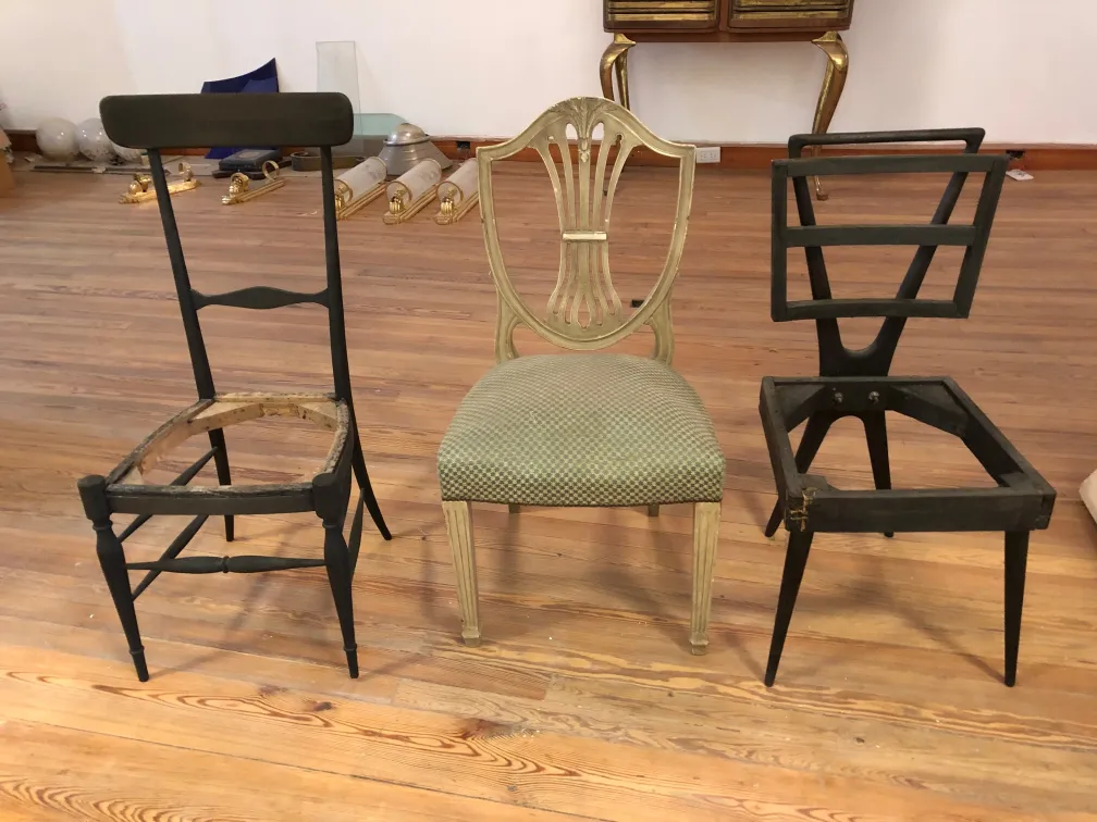 Trois chaises anciennes en cours de restauration, différentes formes visibles.