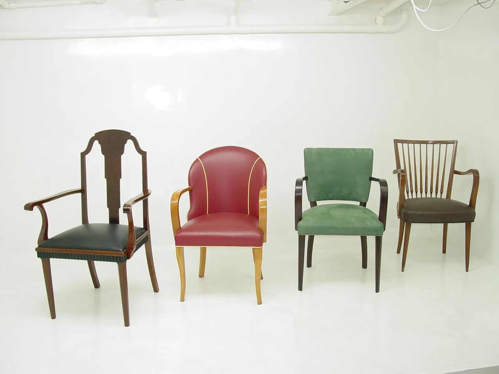 Ensemble de 10 chaises antiques à restaurer, designs et couleurs variés, exposé dans un environnement neutre.