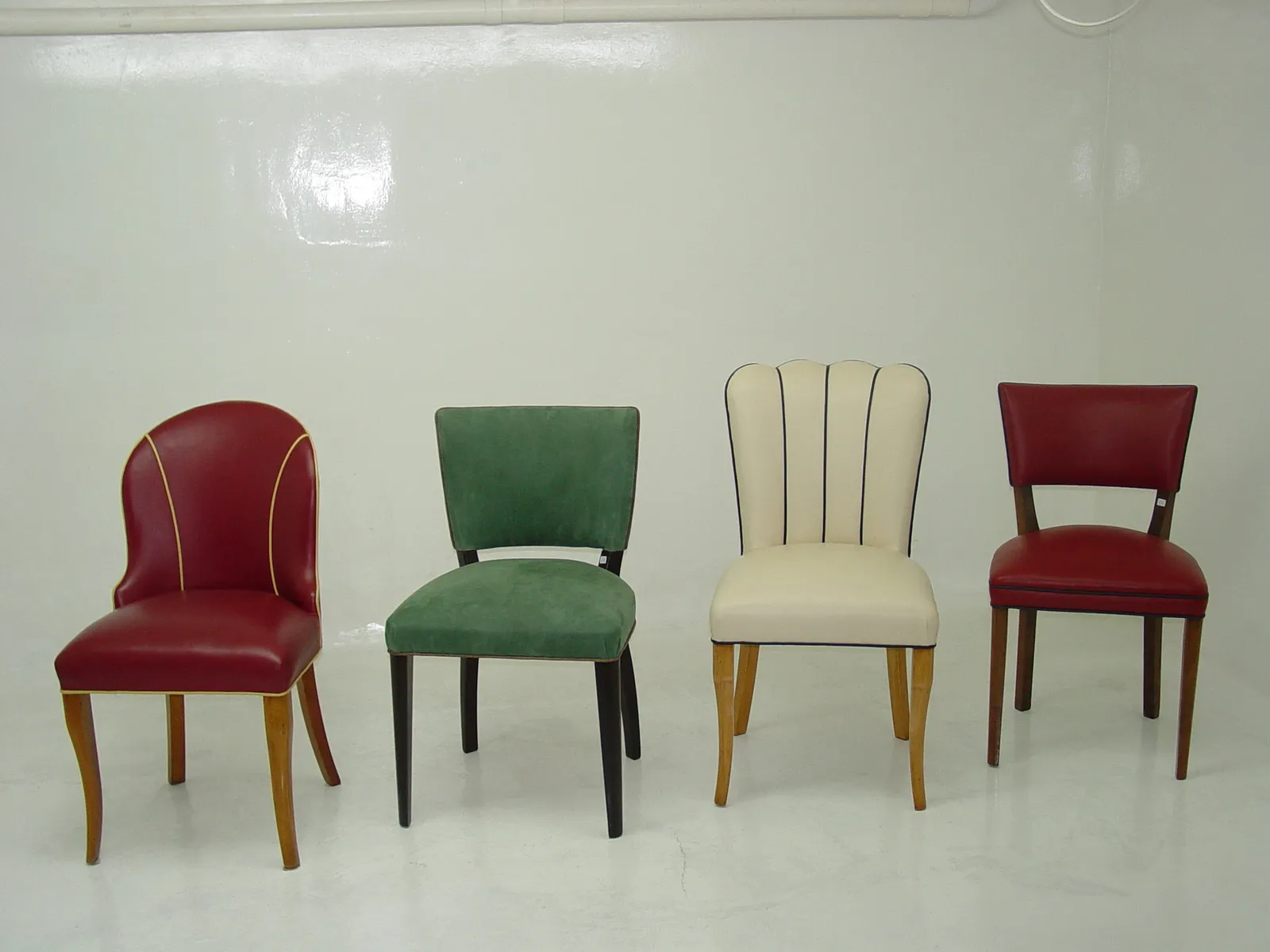 Ensemble de 10 chaises anciennes de différents styles dans un cadre neutre.