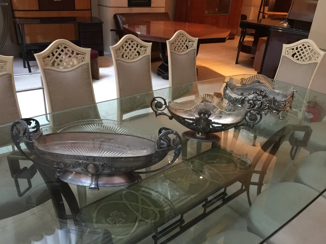 Vista de 12 sillas antiquas en un comedor elegante, junto a dos piezas decorativas