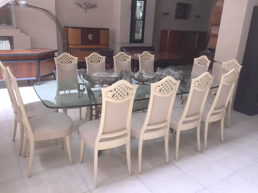 12 chaises anciennes dans une salle à manger élégante avec table en verre