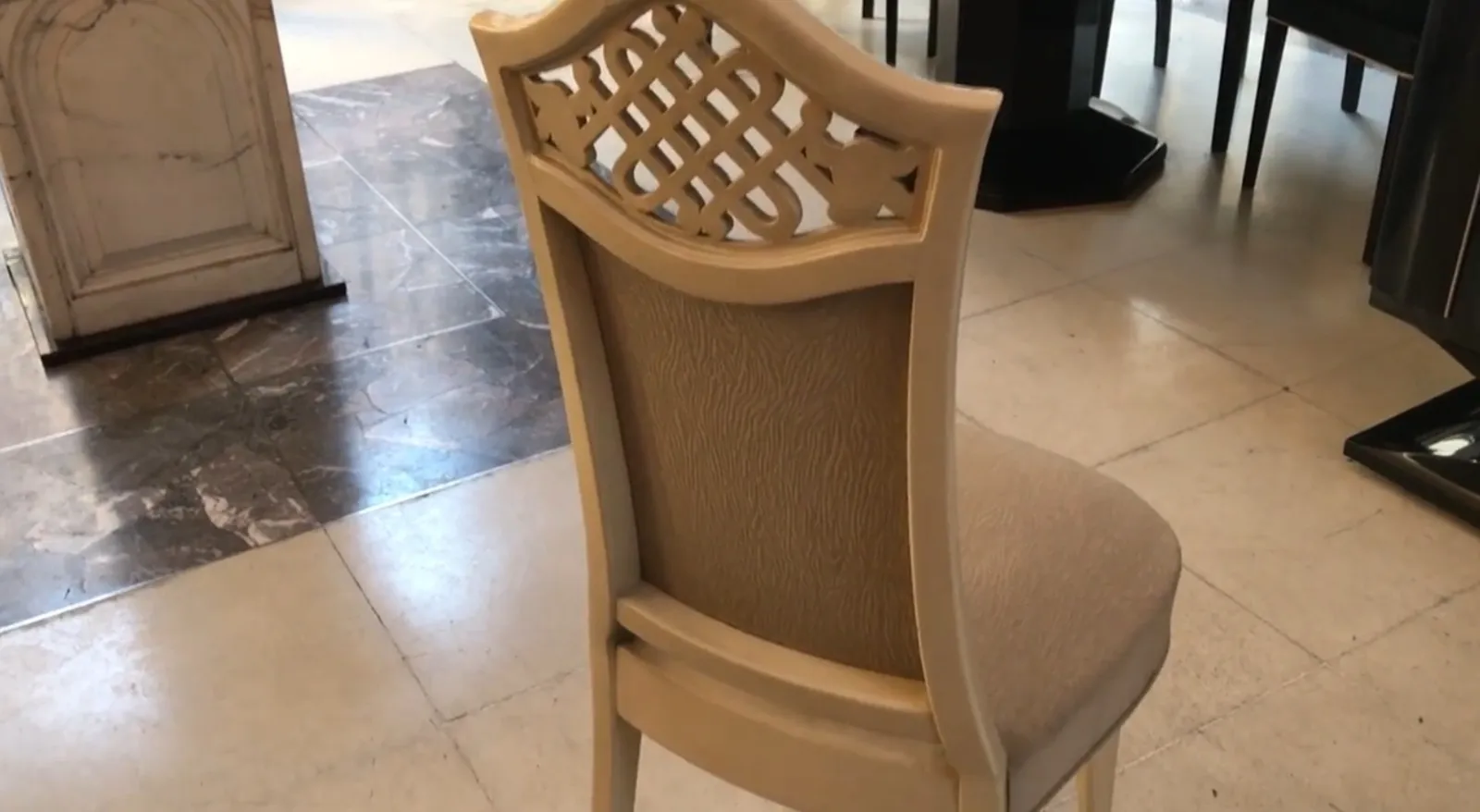 View of the back of 12 antique chairs in an elegant setting