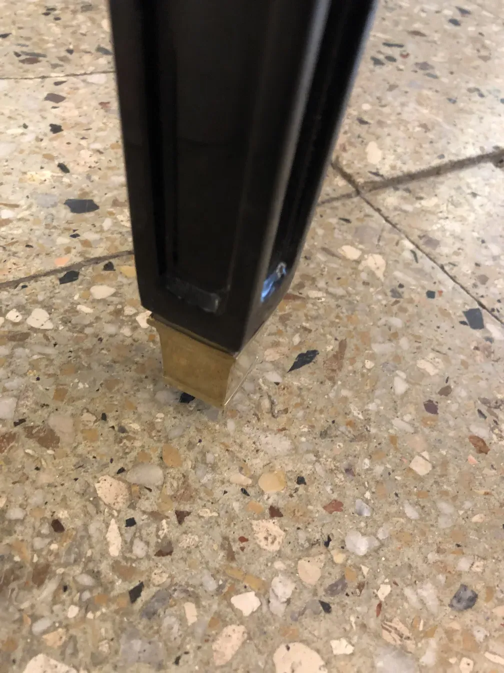 antique stool with metal base, on a stone floor