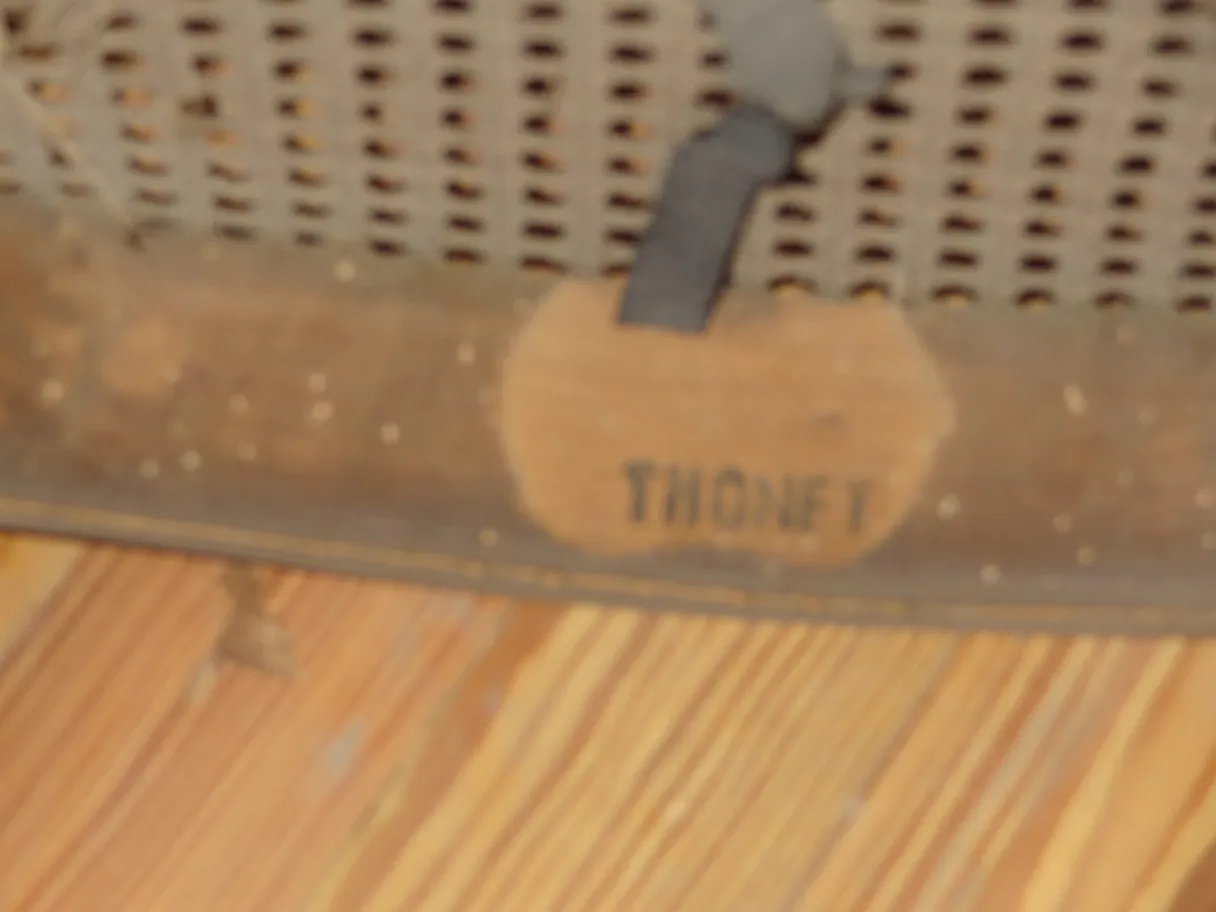 Group of 12 antique Thonet chairs to restore in a vintage setting with a wooden floor.