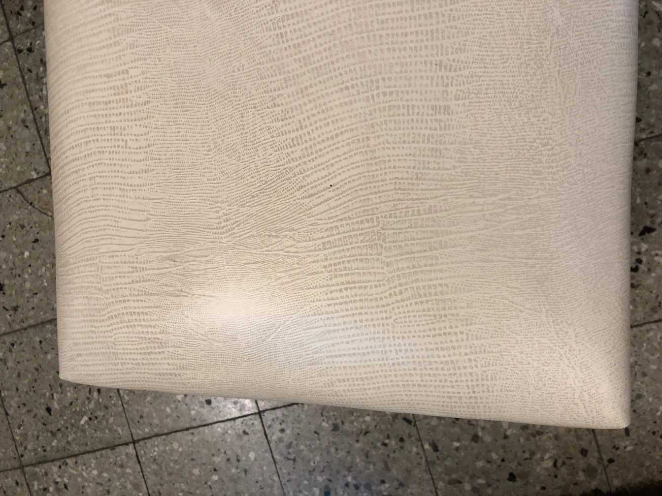 Antique sidewalk stool with a smooth texture on its surface, light background.