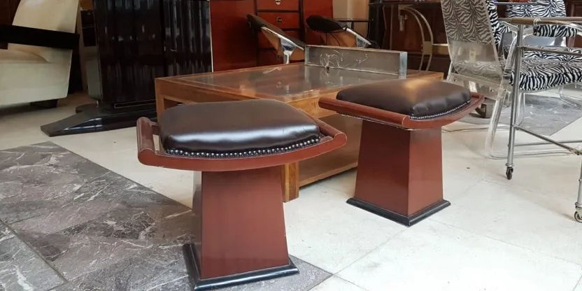 Ein Set stilvoller Hocker in einer gemütlichen Atmosphäre, mit dunkler Polsterung und elegantem Fuß. Perfekt für Vintage-Dekorationen.