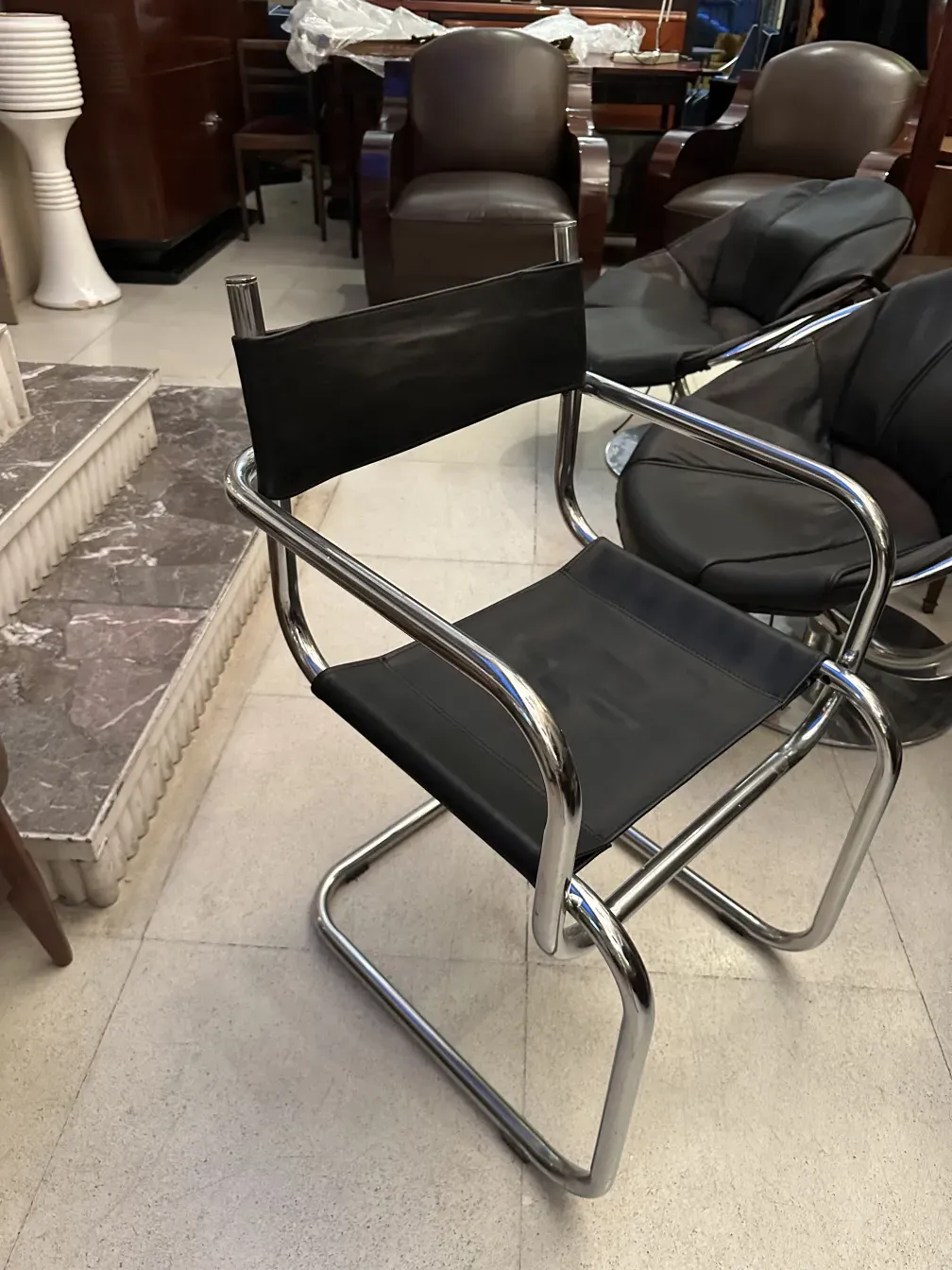 quatre chaises anciennes avec finition noire et détail en métal, dans un cadre élégant