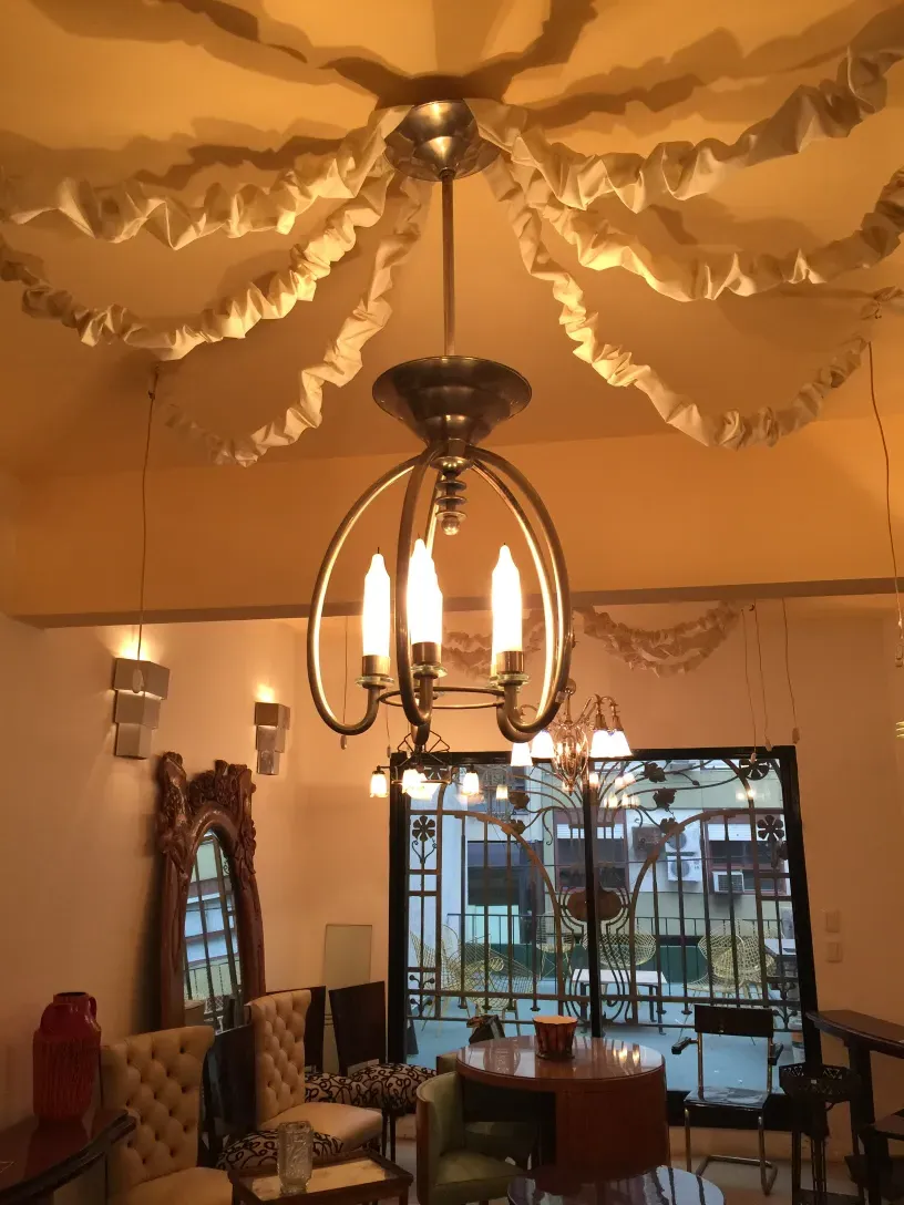 ancienne lampe à suspendre avec des détails blancs et une forme décorative dans un cadre élégant