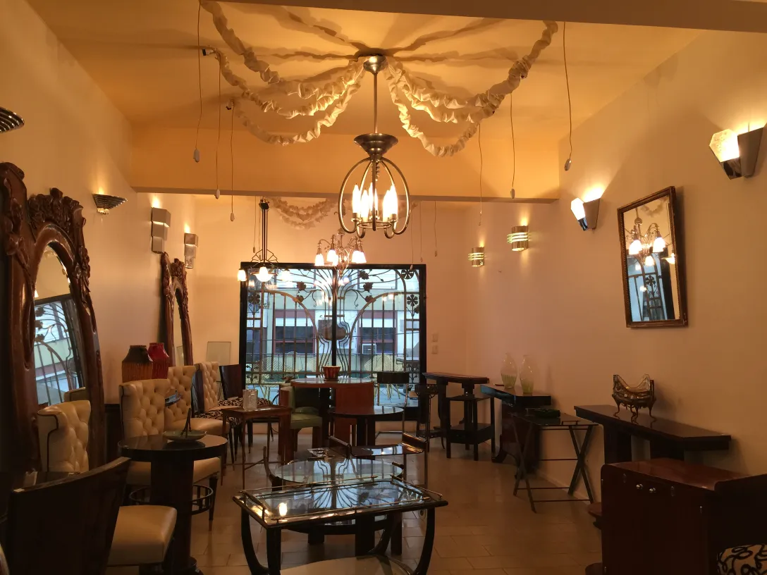 Lámpara de techo antigua decorativa con detalles de Art Deco en un ambiente elegante, rodeada de muebles antiguos.