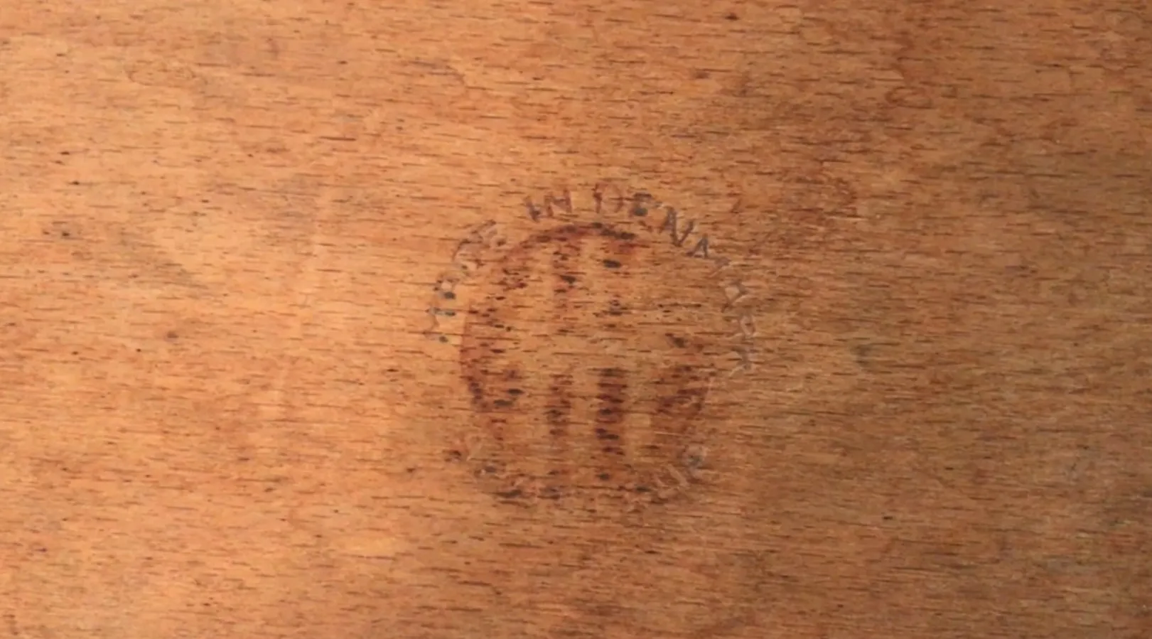 Antigua banqueta de madera con detalle de firma, estilo rústico