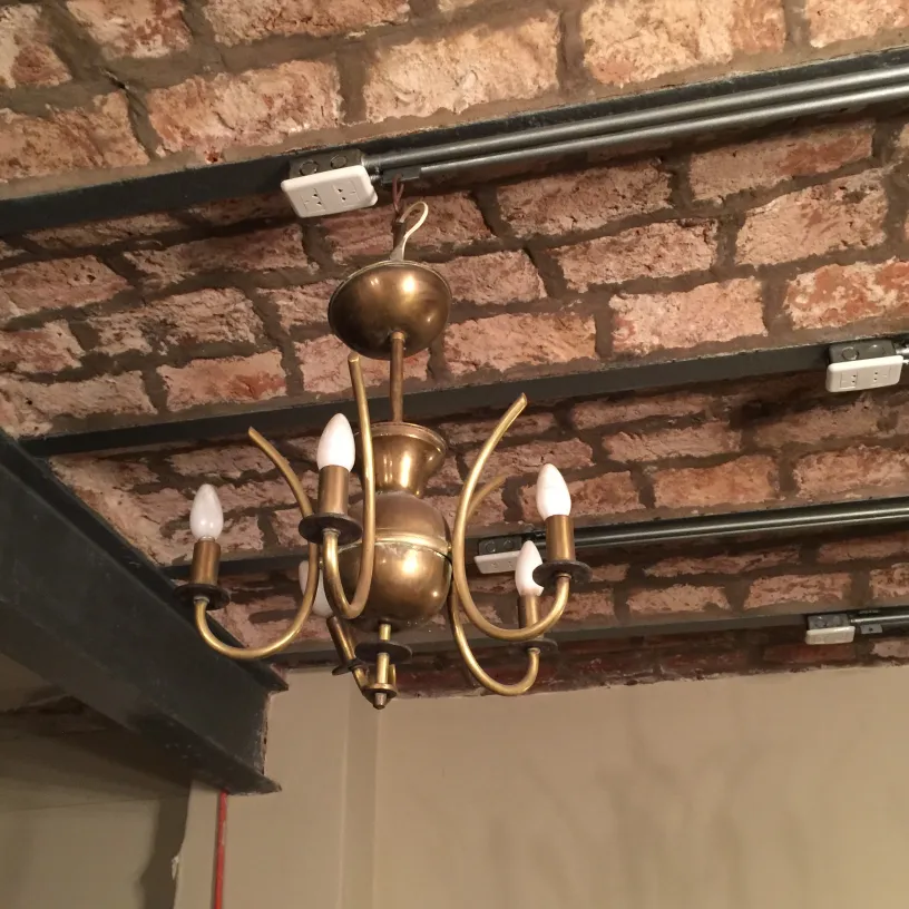 Antike Hängelampe im Art Deco-Stil mit 5 Armen, in einer Umgebung mit freiliegendem Mauerwerk