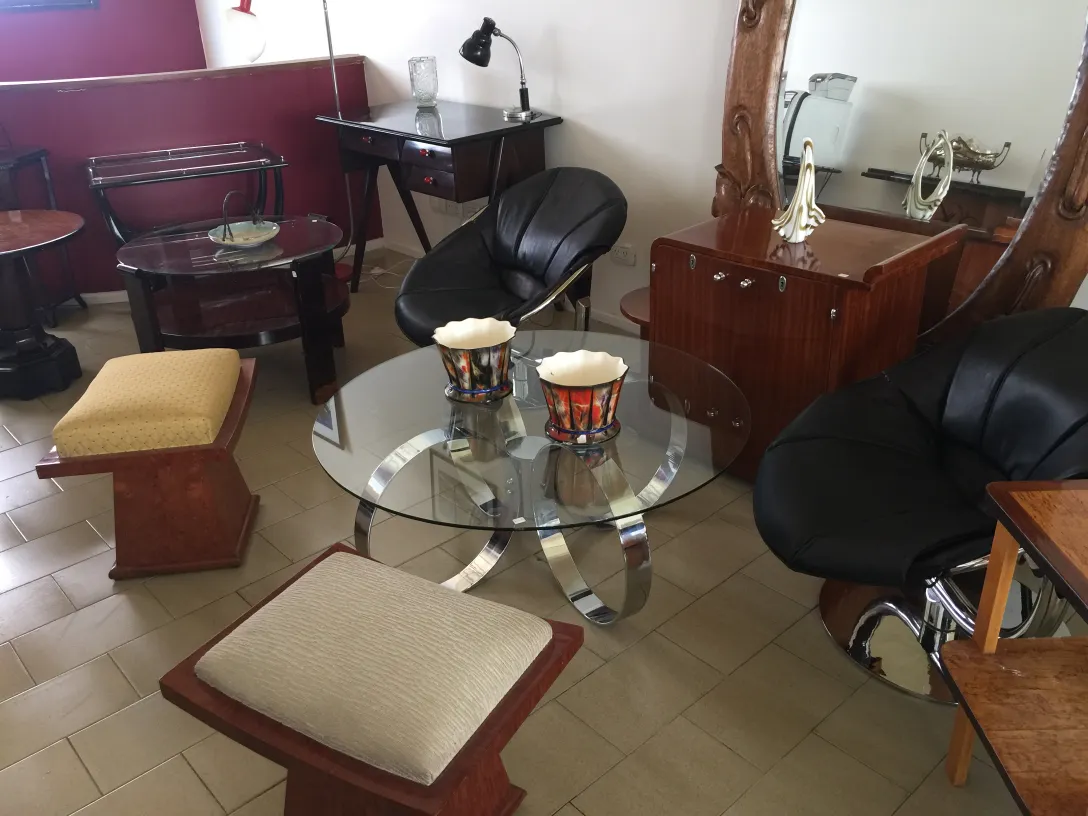 Banqueta moderna con asiento acolchado y estilo elegante, junto a sillones.