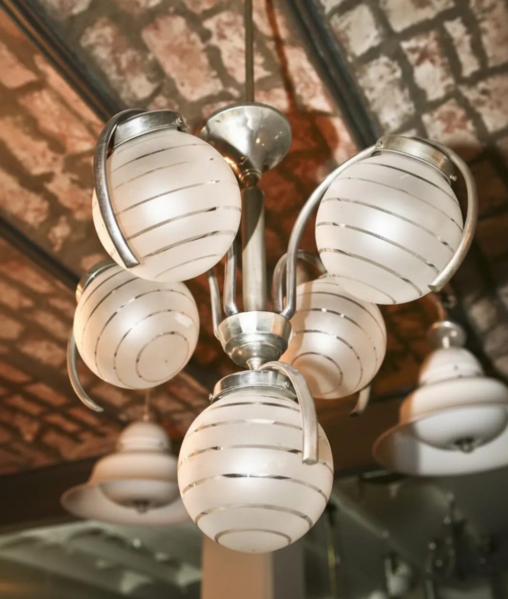 lustre ancien avec globes en verre blanc dans un cadre accueillant