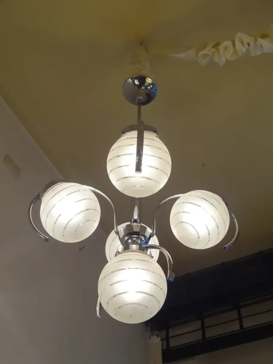 lampada de teto antiga com esferas brancas e design elegante em um ambiente suave