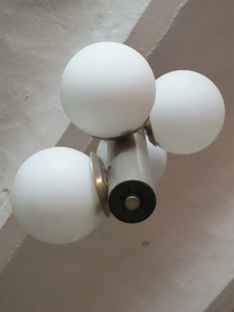 Antique hanging lamp with white glass spheres, neutral background.