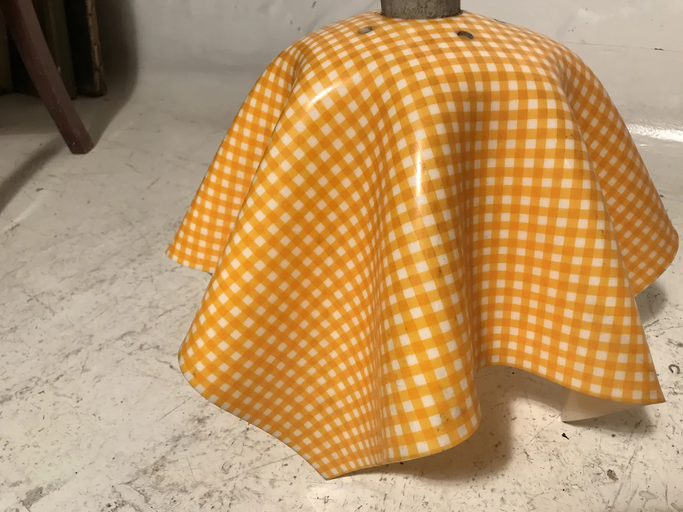 Lâmpada de teto antiga com design alegre, fundo neutro.