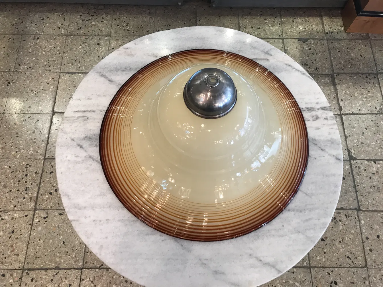 Antica lampada a sospensione con design classico e dettagli circolari, circondata da un ambiente accogliente.