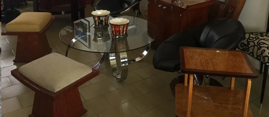 Два старинных табурета рядом со стеклянным столом.