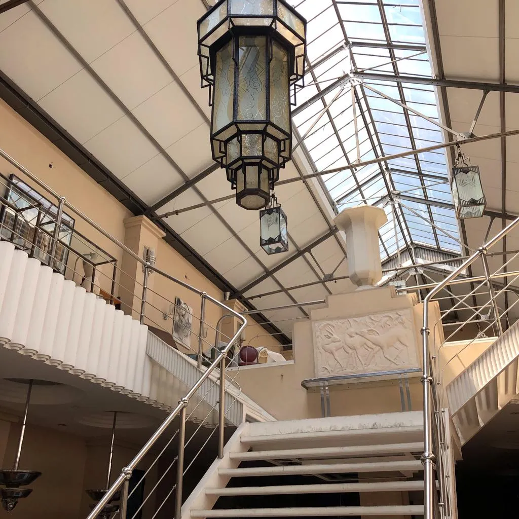 Lanterne antique suspendue dans un cadre élégant avec des détails décoratifs.