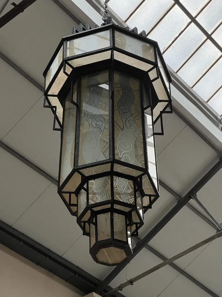 Lanterne antique en verre avec un design élégant, suspendue.