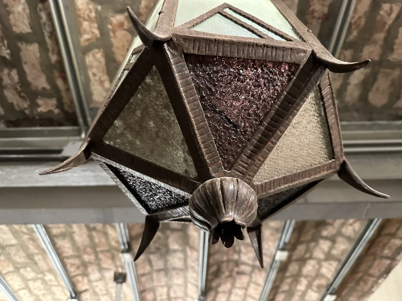 Lanterna antica in vetro con dettagli decorativi.