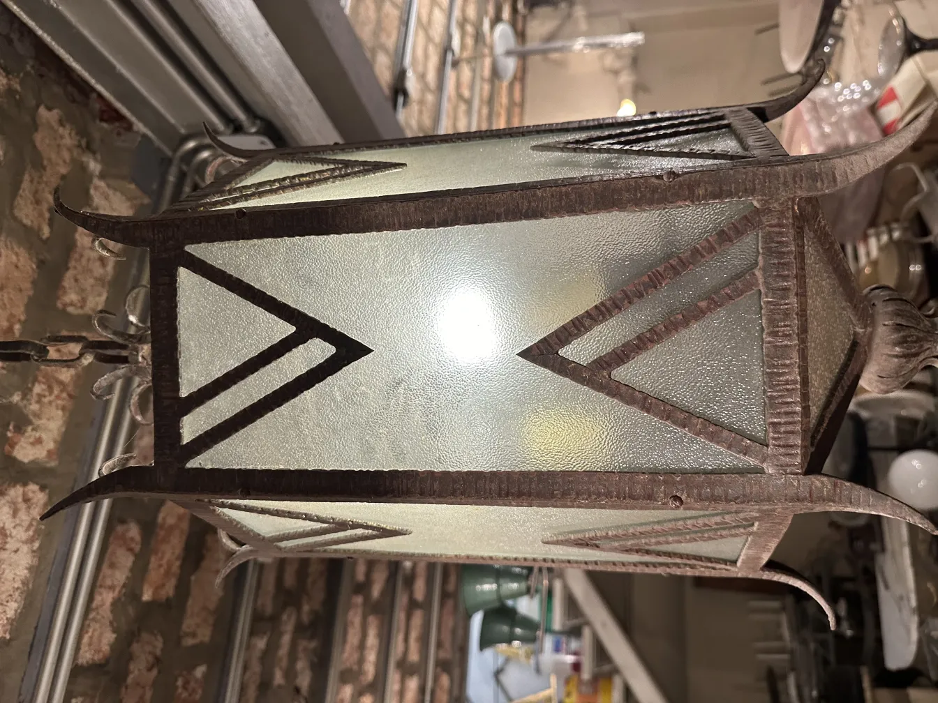 Antike Lampe aus Glas mit geometrischem Design und hellem Licht.