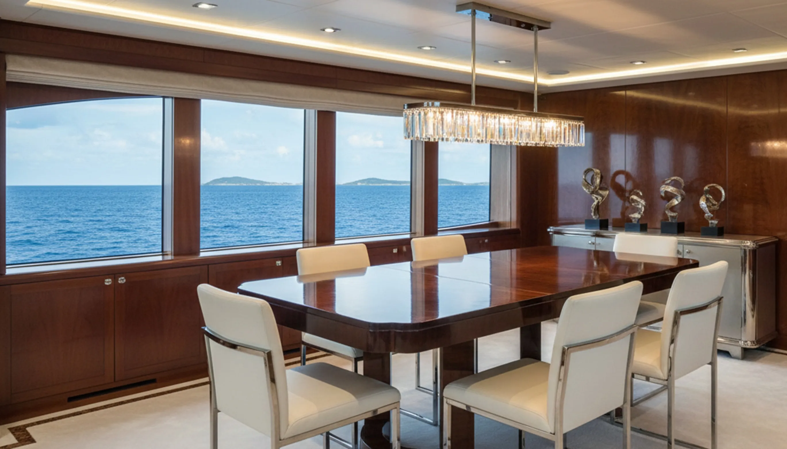 Antique dining table for 8 people in an elegant space with a sea view.