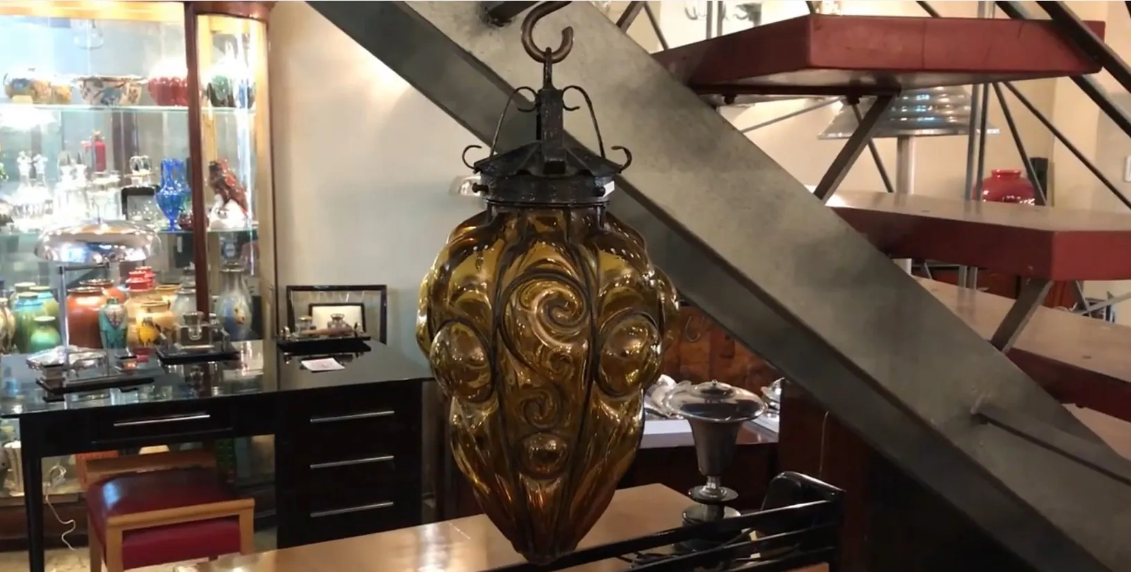 古董棕色玻璃灯笼，带有装饰细节，悬挂着。