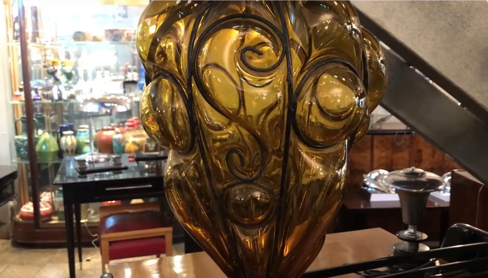 farol antigo de vidro com detalhes decorativos em um ambiente vintage