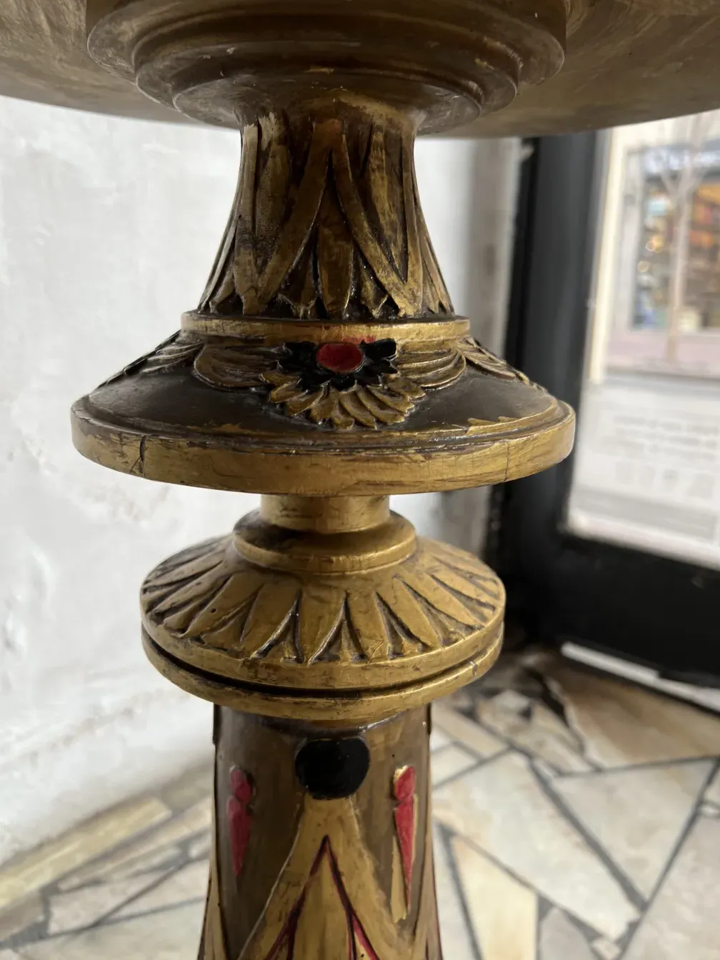 Scultura antica decorata con dettagli colorati, ambiente classico.