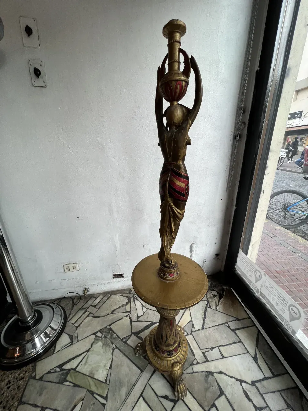 Antike Bronze-Skulptur mit roten Details, elegant und markant.