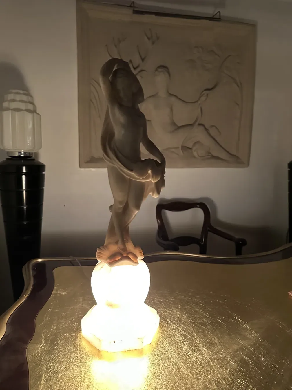 Antique sculpture of a human figure with a decorative background