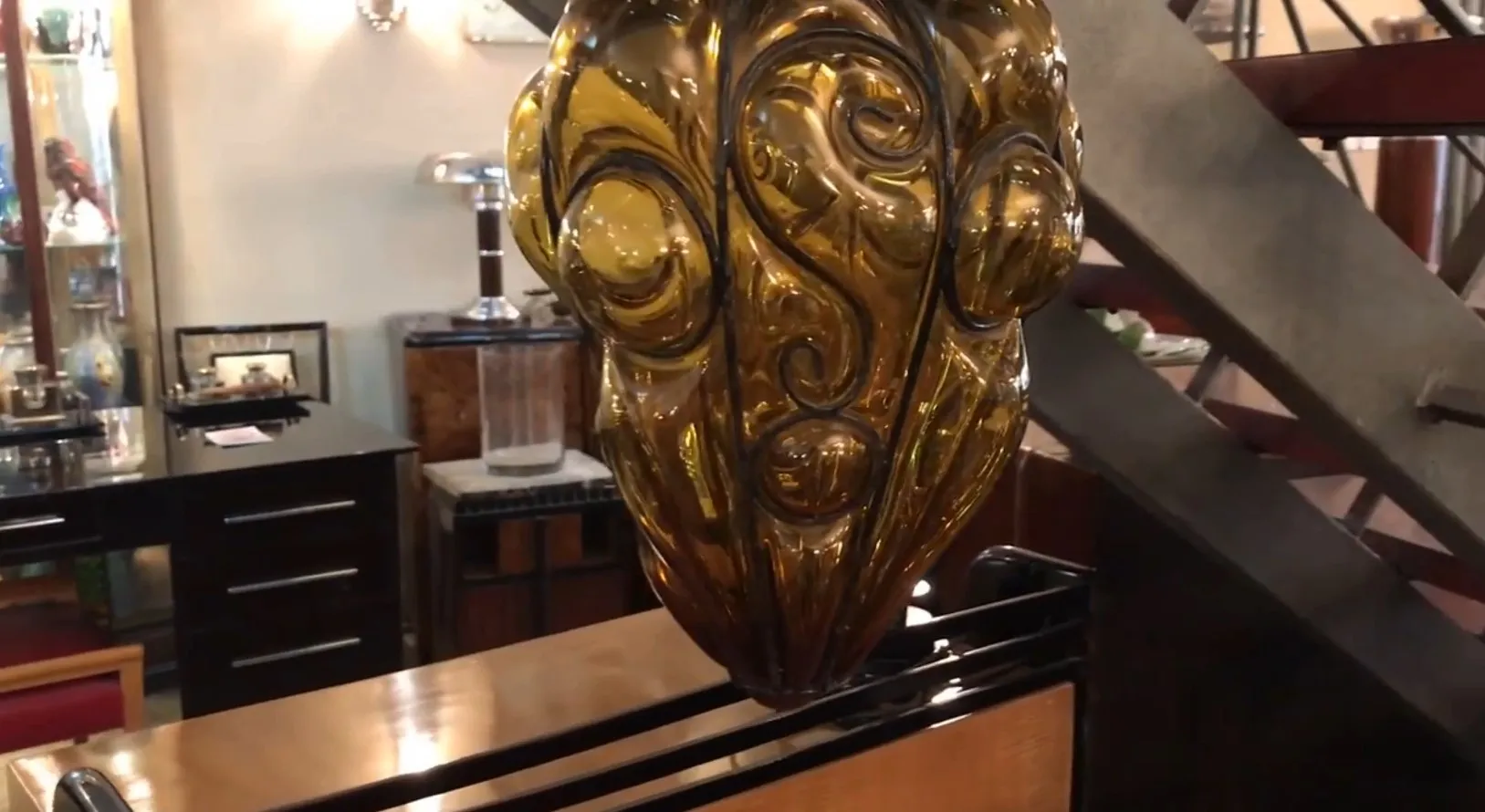 Antique amber glass lantern with decorative design in a vintage setting.