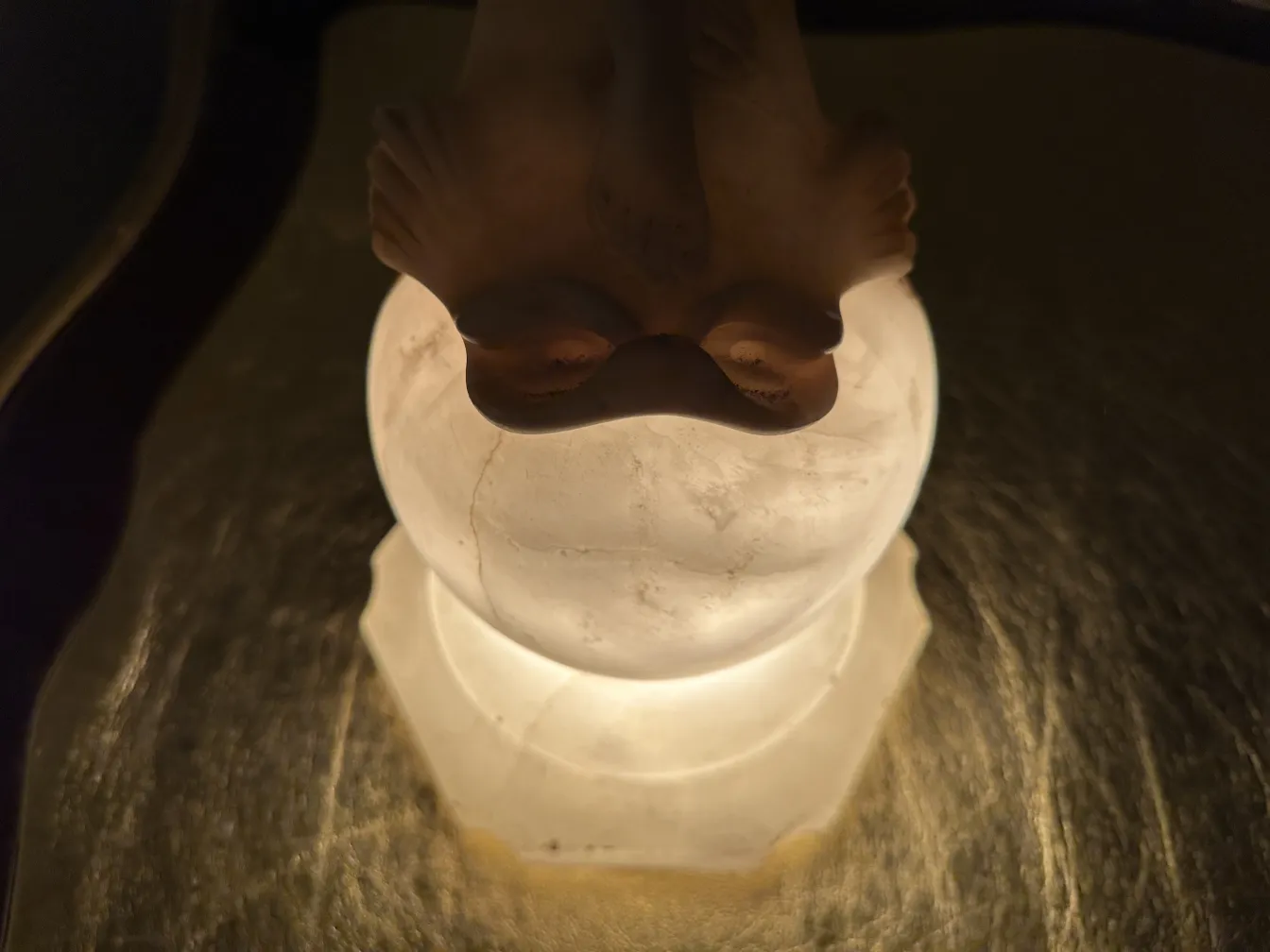 alte skulptur mit leuchtendem fuß, der details hervorhebt