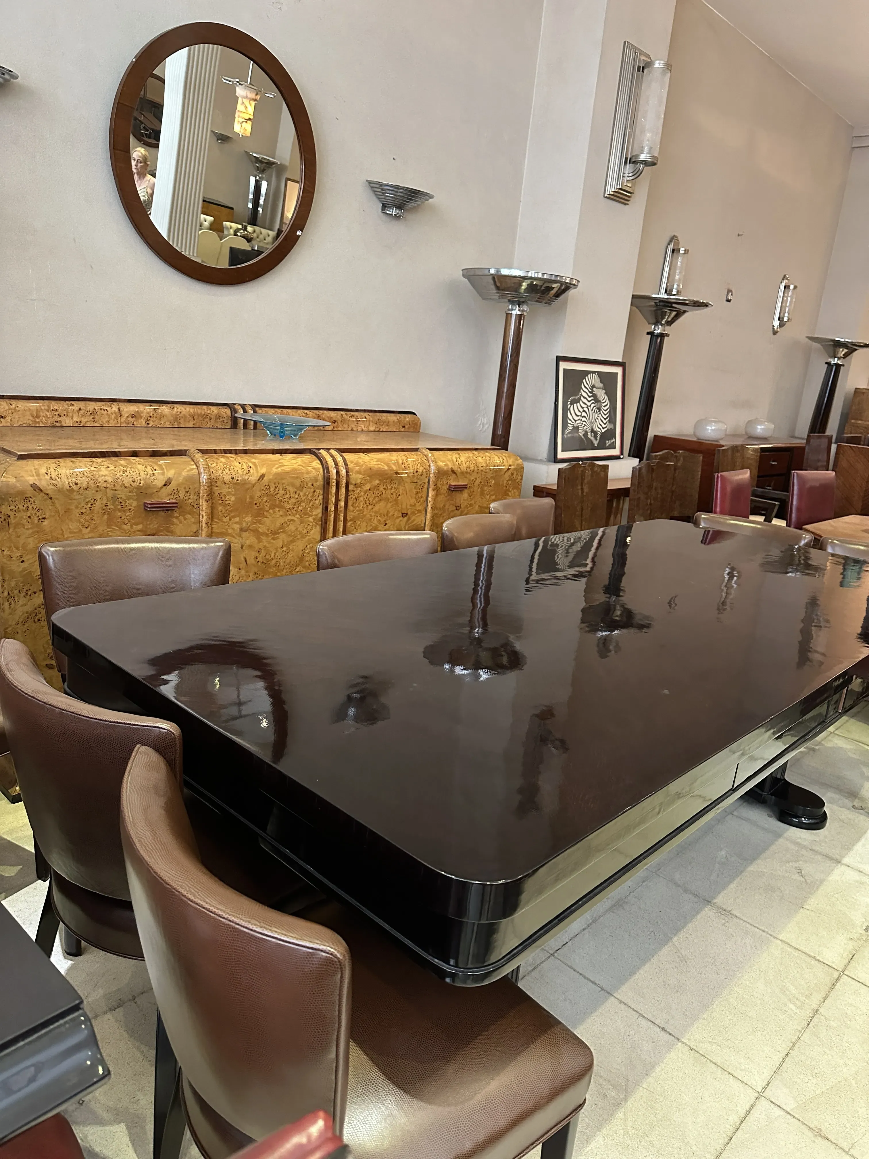 Mesa de jantar antiga Art Deco para dez pessoas, com cadeiras de couro marrom, ambiente elegante.