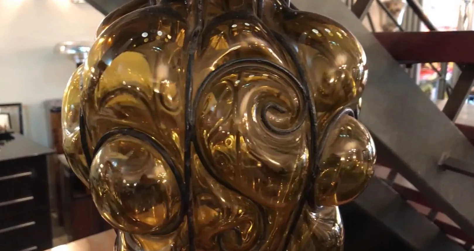 lanterna antica con design ondulato in ambra, in un negozio di antiquariato