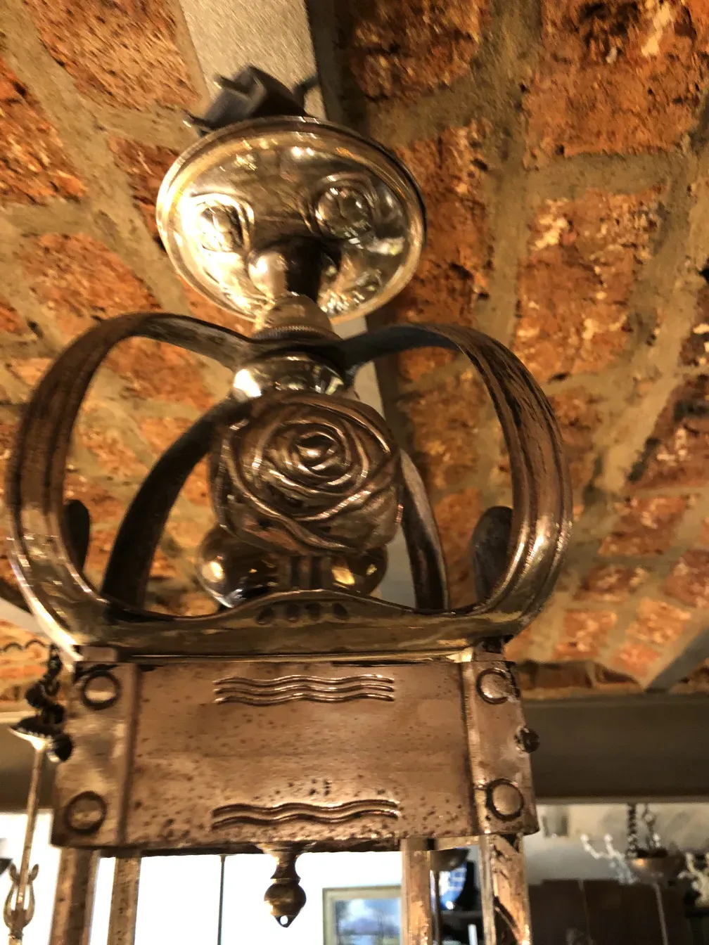 Lampada a sospensione antica con dettagli floreali in un ambiente vintage.