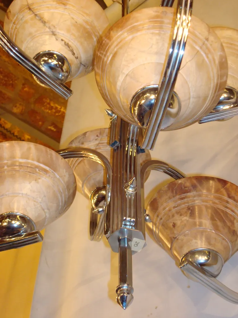 lustre ancien avec plusieurs abat-jours ronds dans un cadre décoratif