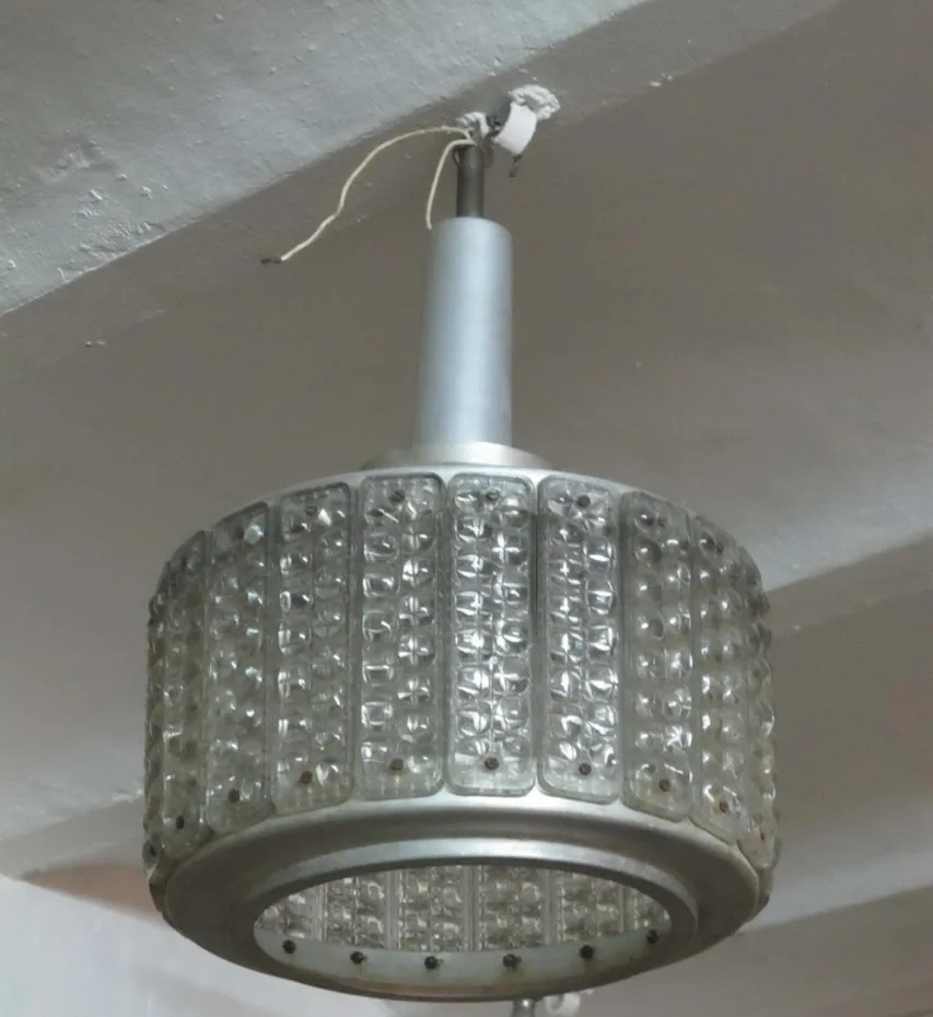 Antique hanging lamp with round Art Deco design and possible details in the environment.