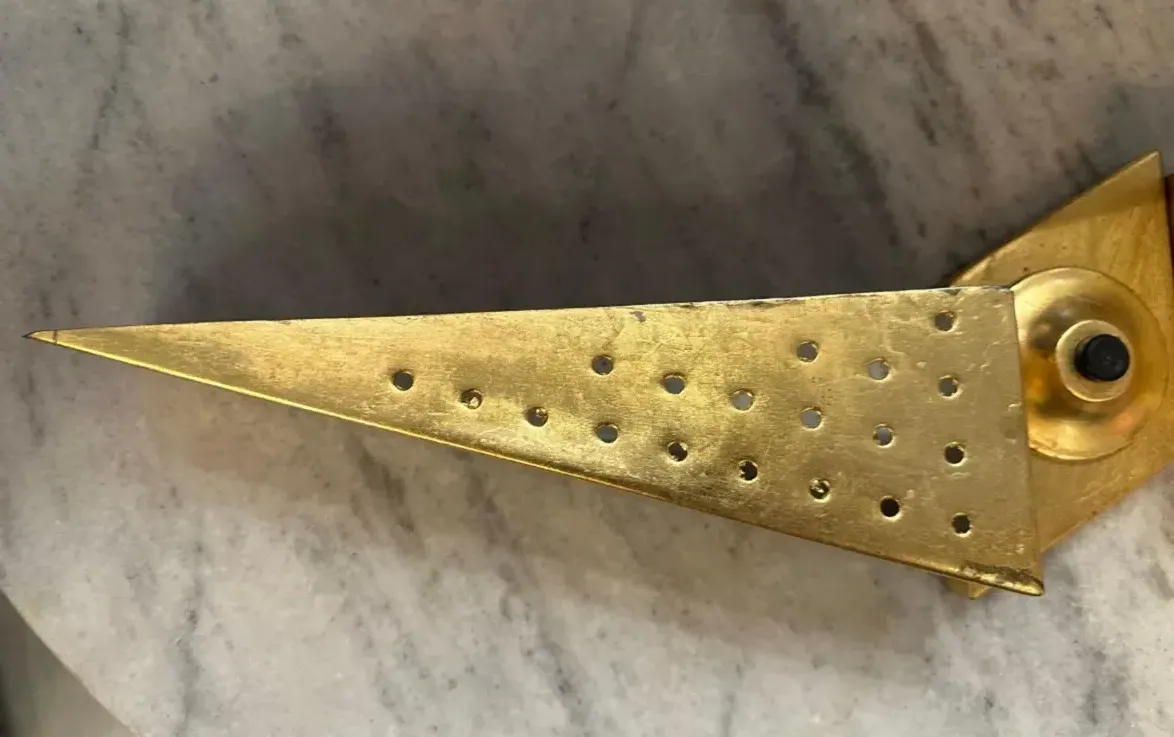 Antique wall sconce with perforated design, cozy ambiance.