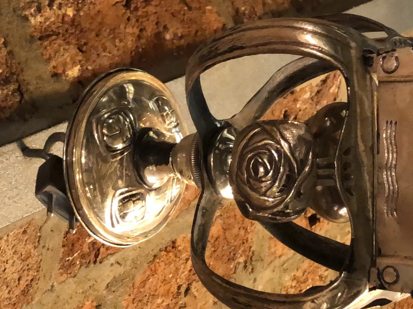 Farol antiguo con detalles de rosas y fondo de ladrillo